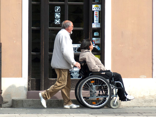 Senior schiebt den Rollstuhl von Senioren