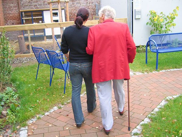 Pflegerin geht mit Senioren spazieren