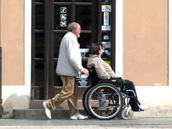 Senior schiebt den Rollstuhl von Senioren